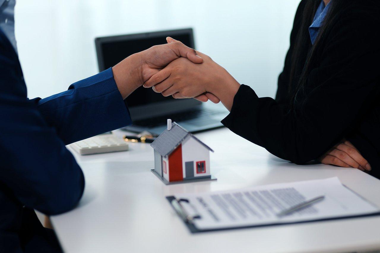 Réunion de négociation immobilière entre un agent et des clients lors d'une réunion de real estate negotiation meeting.