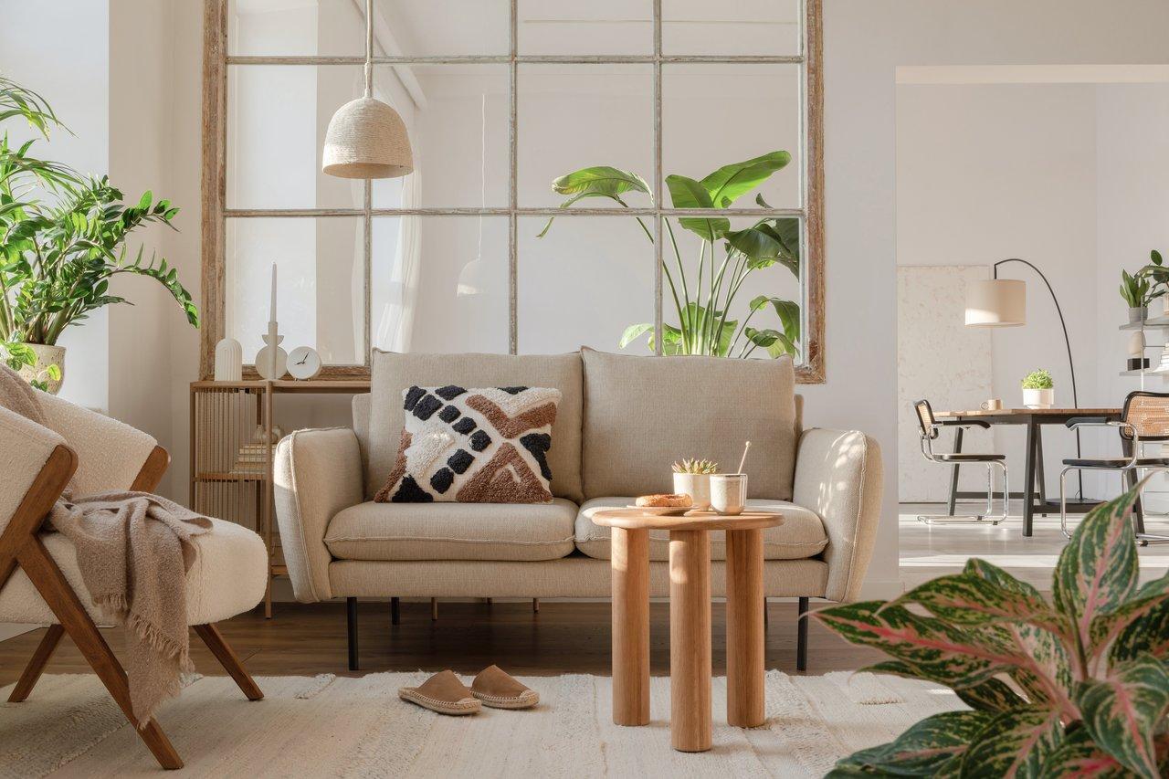 Un petit salon optimisé avec meubles multifonctions, étagères hautes et miroirs stratégiques.