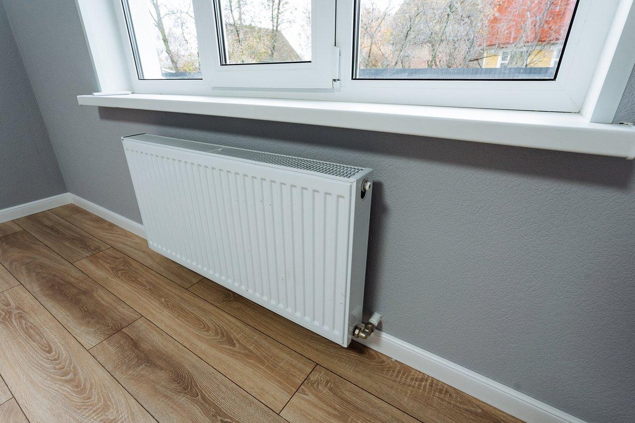 Système de chauffage intérieur moderne avec radiateur blanc sous fenêtres pour un confort optimal.