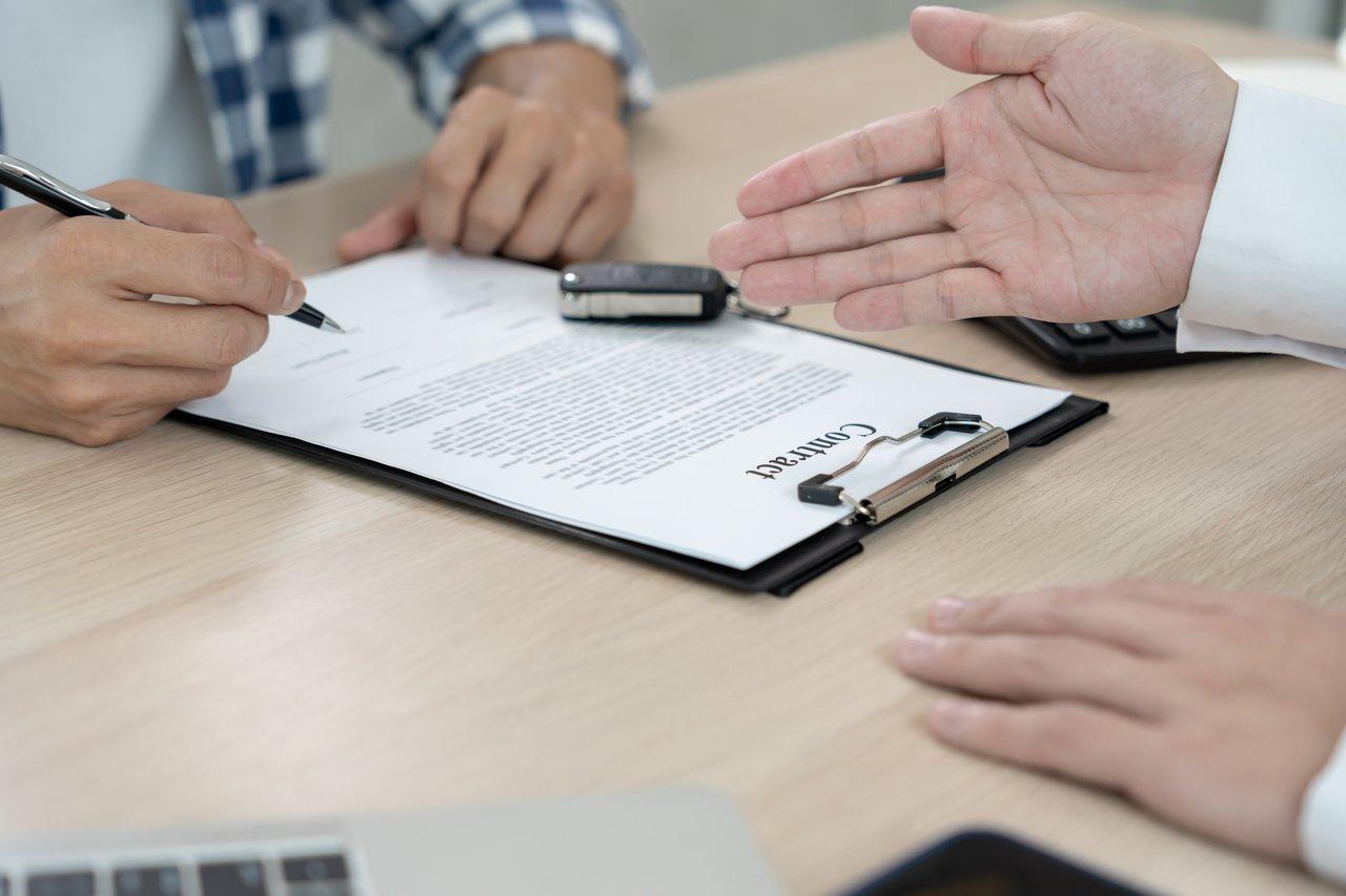 Une personne signe un contrat d'assurance habitation, attestant de sa couverture pour son logement.