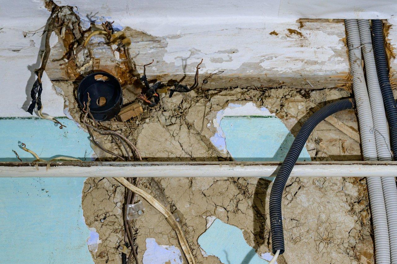 Câblage électrique vétuste dans une vieille maison en bois, nécessitant une refonte pour garantir la sécurité électrique.