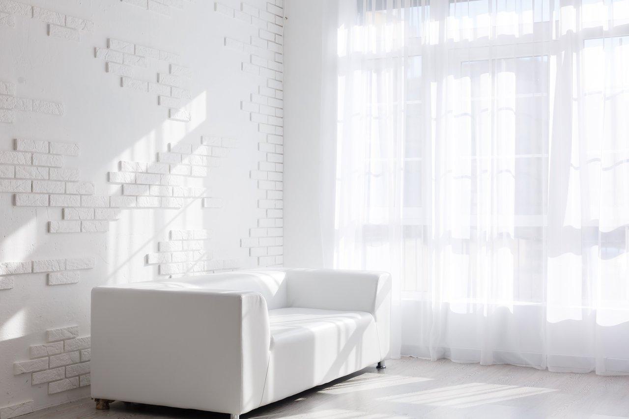 Salon lumineux et épuré avec mobilier minimaliste, idéal pour séduire les acheteurs potentiels.